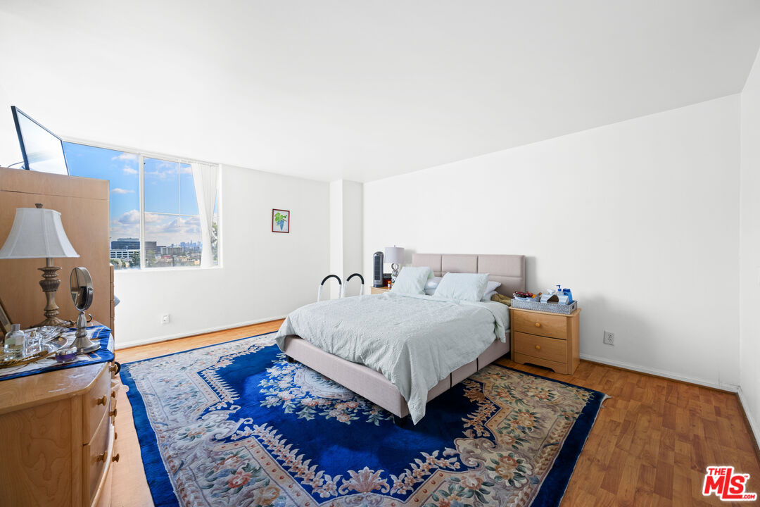 100 South Doheny Drive, Unit 512 Los Angeles, CA 90048 - Photo 18 of 37 a bedroom with a bed and wooden floor