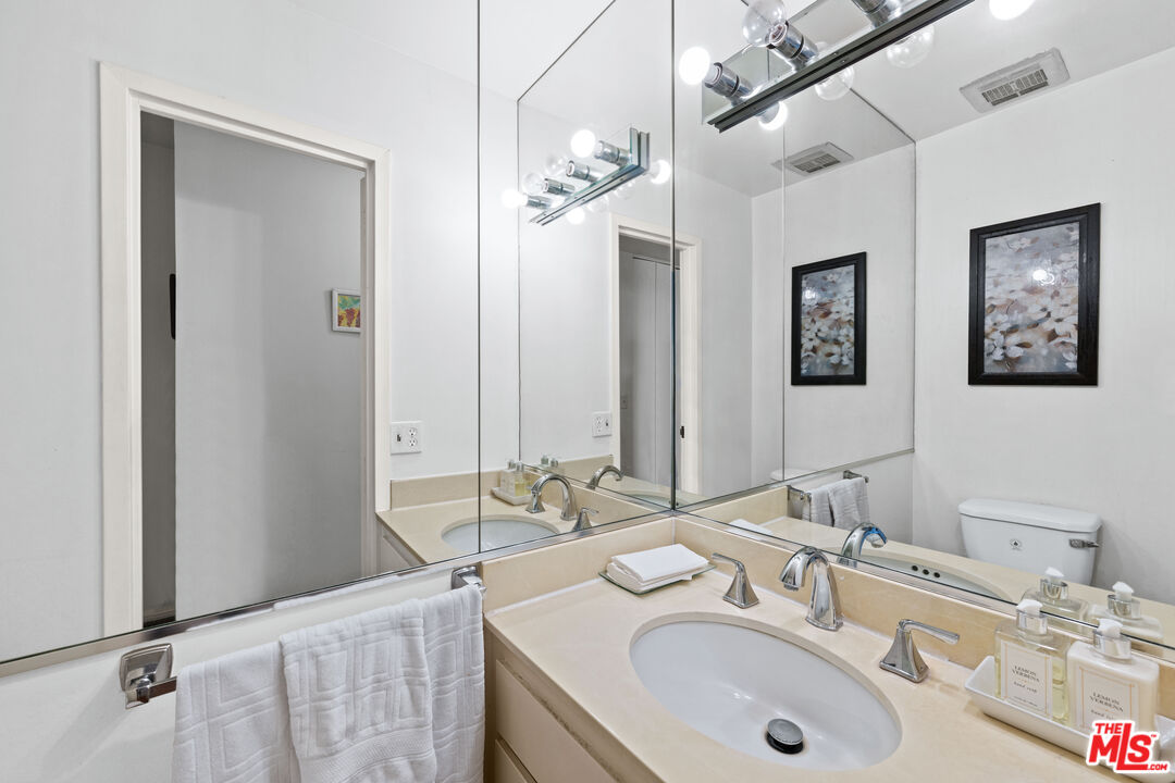 100 South Doheny Drive, Unit 512 Los Angeles, CA 90048 - Photo 27 of 37 a bathroom with a granite countertop double vanity sinks and a mirror