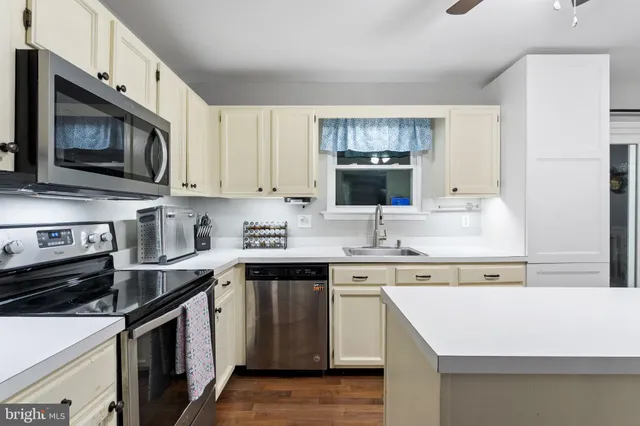 a kitchen with stainless steel appliances a stove microwave and sink