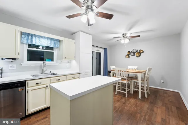 a kitchen with a dining table chairs cabinets and stainless steel appliances