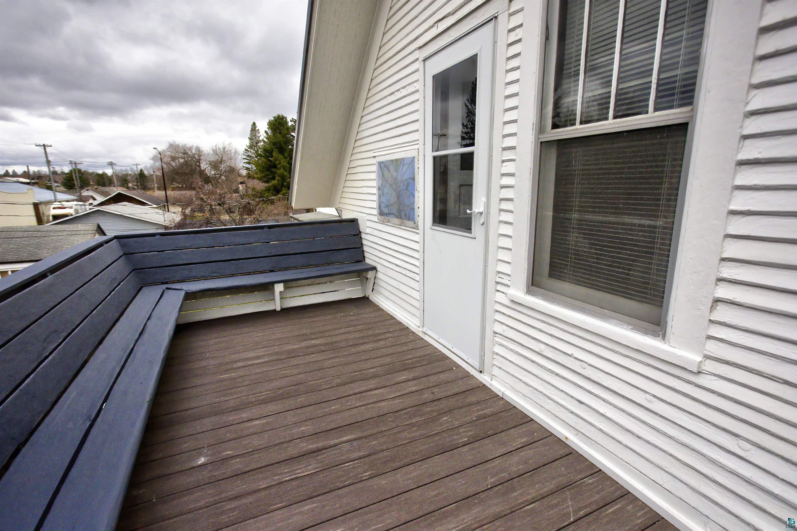 24 East Conan Street Ely, MN 55731 - Photo 20 of 27 Exterior deck featuring wood-finish flooring, built-in corner seating, and white horizontal siding