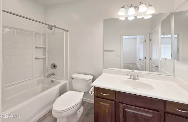 a bathroom with a sink a toilet a mirror a bathtub and shower