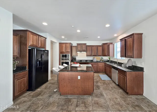 a kitchen with stainless steel appliances granite countertop a refrigerator and a stove