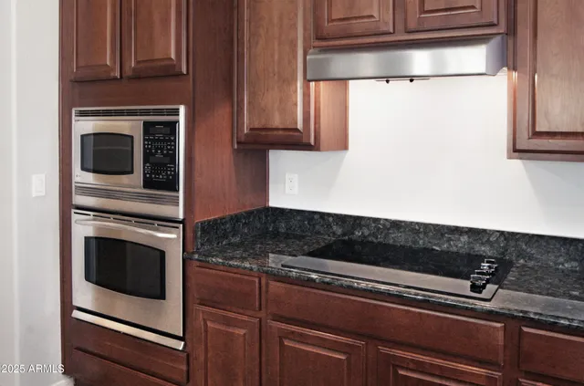 a kitchen with granite countertop cabinets and steel stainless steel appliances