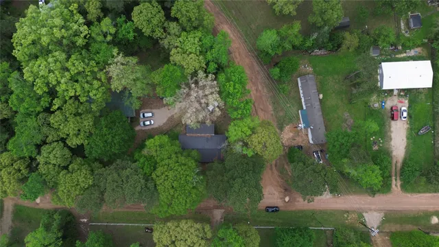an aerial view of residential house with outdoor space and trees all around