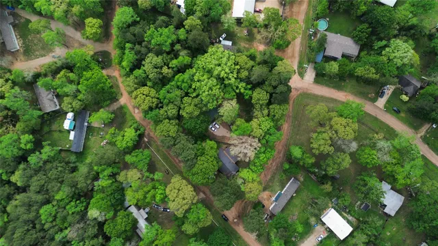 an aerial view of residential house with outdoor space and trees all around