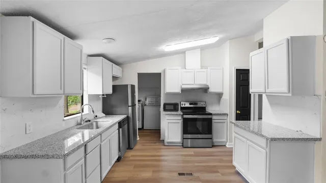 a kitchen with stainless steel appliances a refrigerator stove and sink