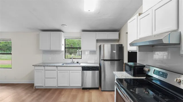 a kitchen with stainless steel appliances a refrigerator sink and stove