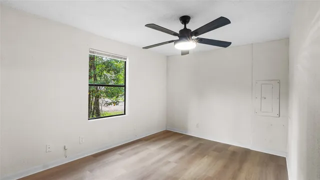 an empty room with a window and a fan