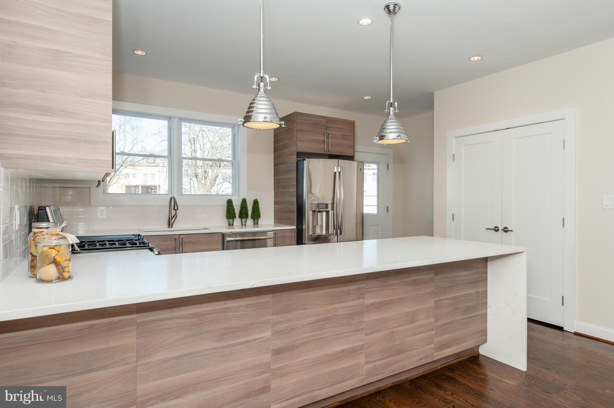 1608 Potomac Avenue Southeast Washington, DC 20003 - Photo 4 of 29 a large kitchen with kitchen island a stove a sink a center island and wooden floor