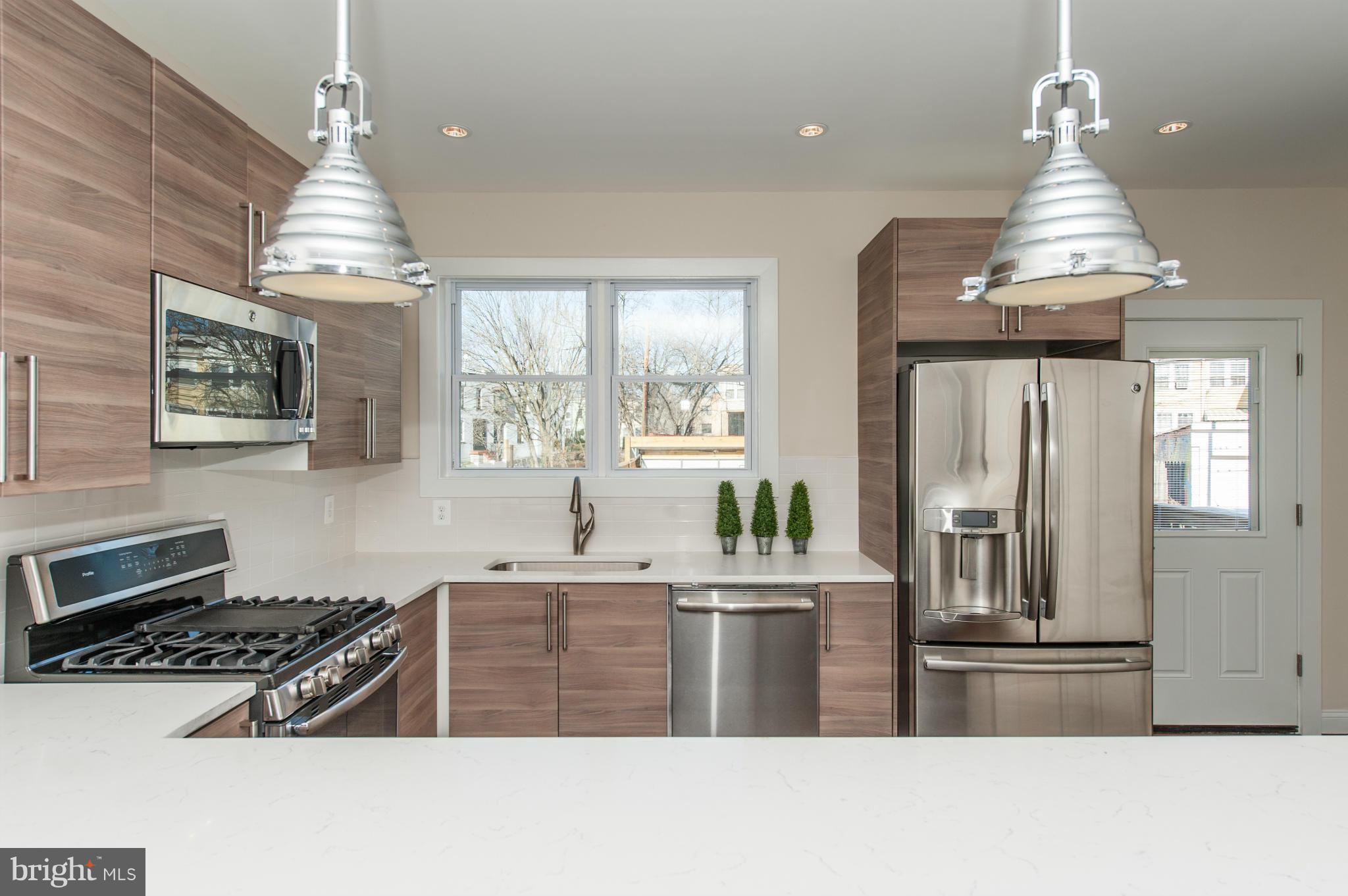 1608 Potomac Avenue Southeast Washington, DC 20003 - Photo 5 of 29 a kitchen with stainless steel appliances a stove a refrigerator a sink and white cabinets