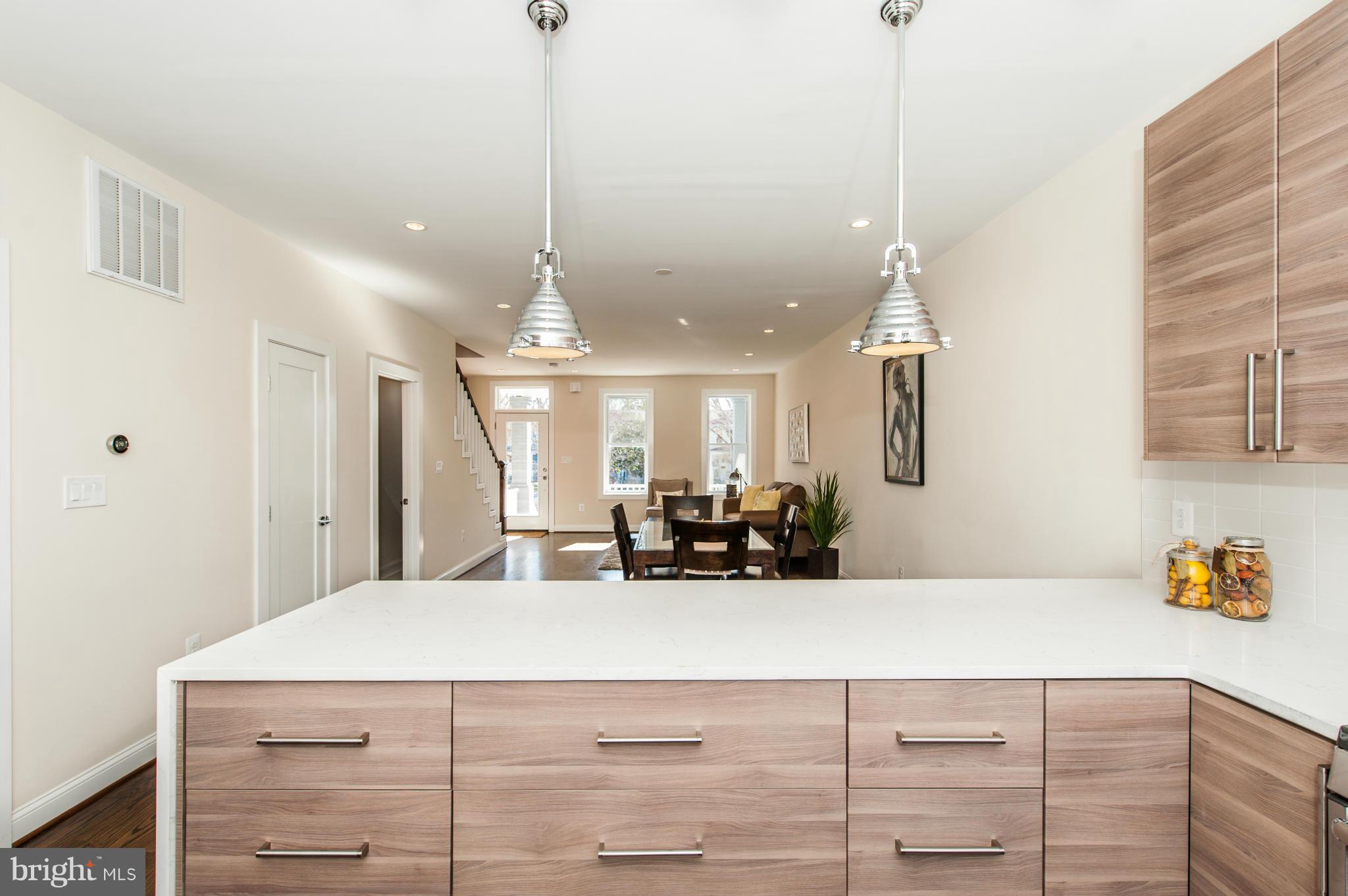 1608 Potomac Avenue Southeast Washington, DC 20003 - Photo 6 of 29 a view of a kitchen with kitchen island stainless steel appliances a sink a counter top space and living room view