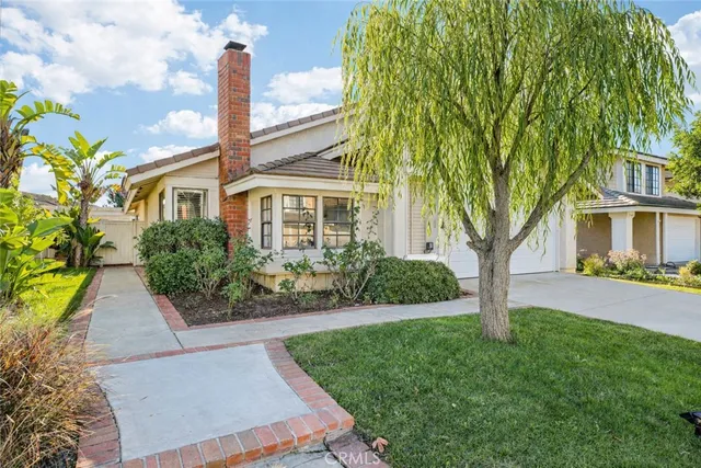 a front view of a house with a garden and plants