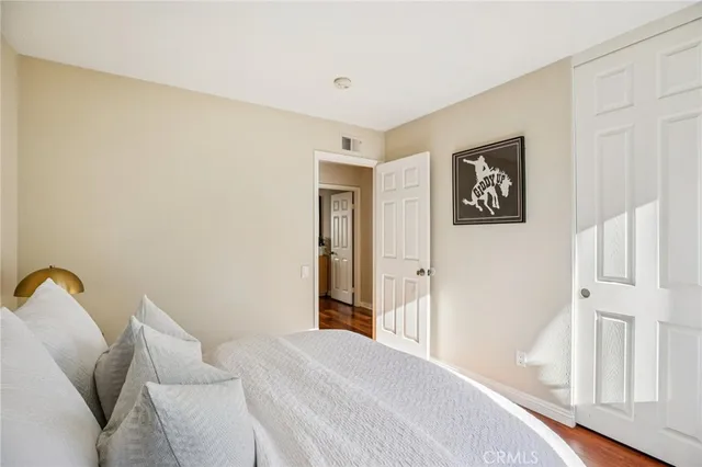 a bedroom with a bed and a painting on the wall