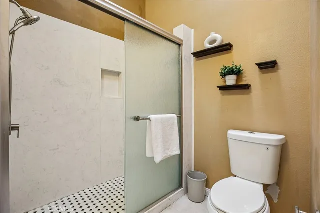 a bathroom with a toilet and a shower