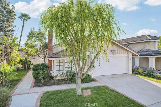 a front view of a house with a yard and potted plants