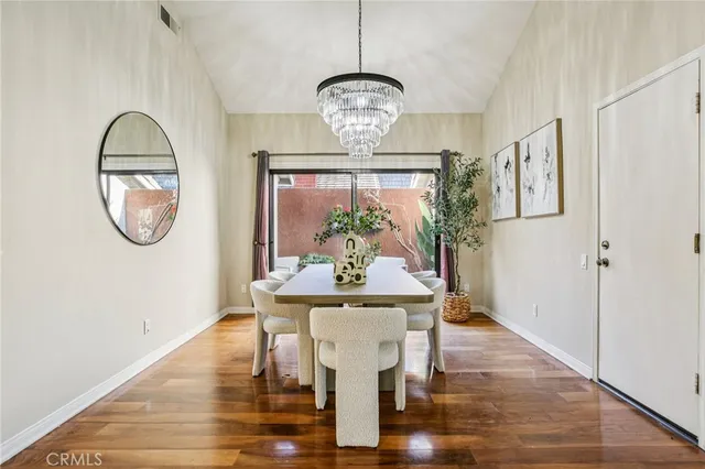 a view of a dining room with furniture a chandelier and wooden floor