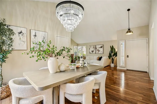 a dining room with furniture potted plants and wooden floor