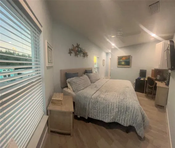 a bedroom with a bed and wooden floor