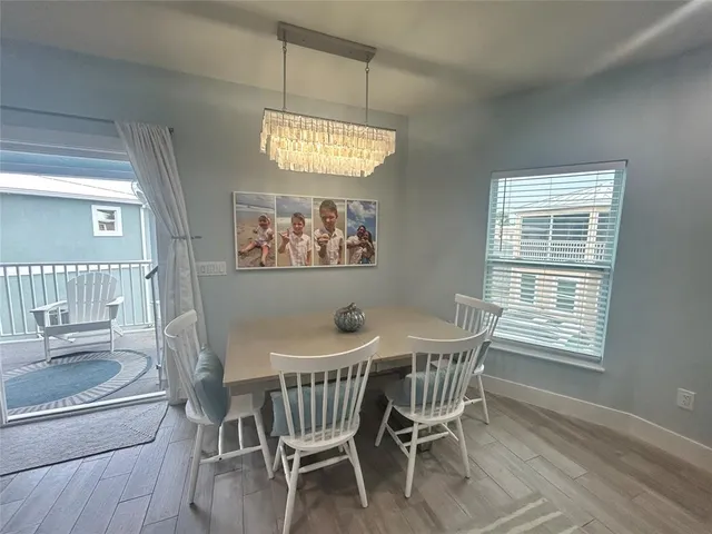 a view of a dining room with furniture a chandelier and wooden floor