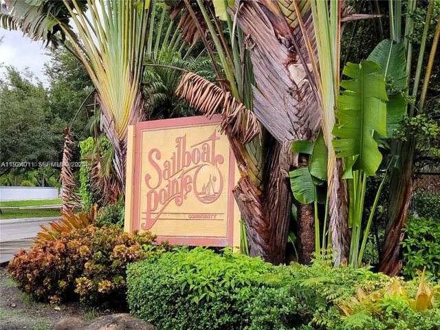 a sign that is on a brick building with a tree in front