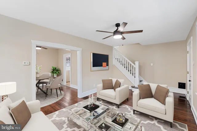 a living room with furniture a ceiling fan a rug and a window