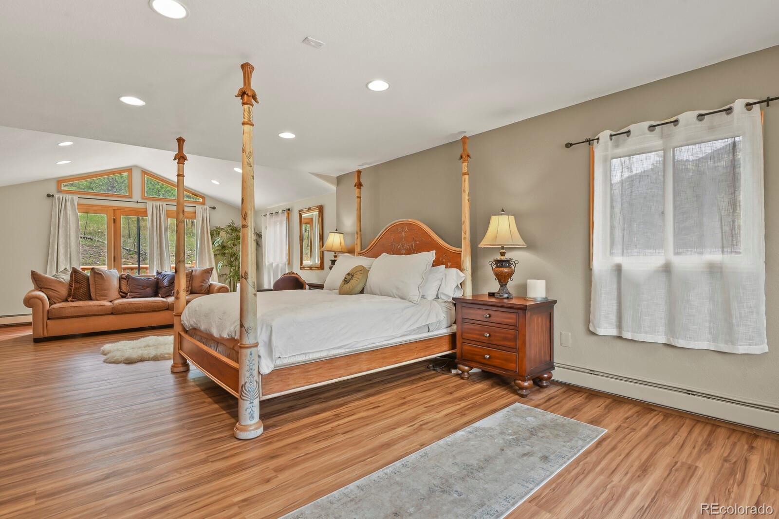 417 Witter Gulch Road Evergreen, CO 80439 - Photo 26 of 50 a bedroom with a bed and wooden floor