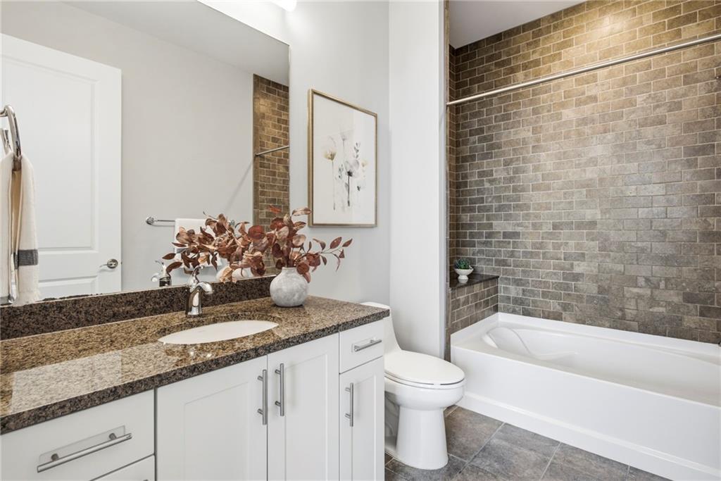 270 17th Street Northwest, Unit 4306 Atlanta, GA 30363 - Photo 19 of 37 a bathroom with a granite countertop sink a toilet and bathtub