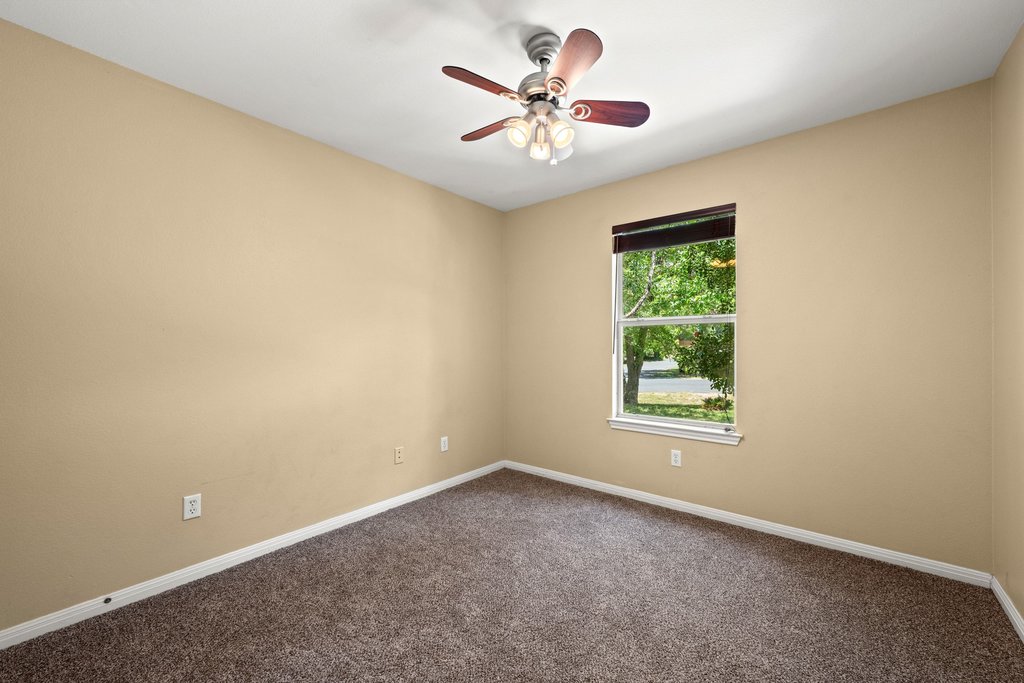5208 Sioux Lane Austin, TX 78734 - Photo 17 of 35 A quiet bedroom featuring plush carpeting, a single window, and a convenient ceiling fan.