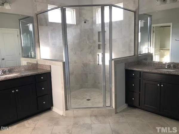 a bathroom with a granite countertop shower sink and mirror