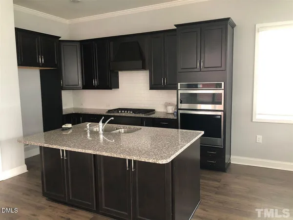 a kitchen with a sink a microwave and refrigerator