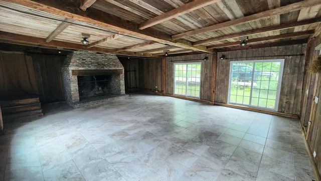 a view of empty room with fireplace and windows