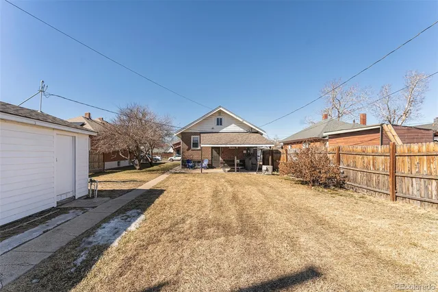 a view of house with yard and wooden fence