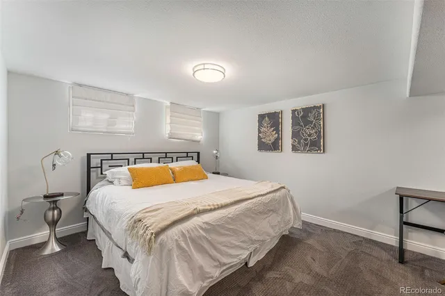 a bedroom with a bed and painting on the wall