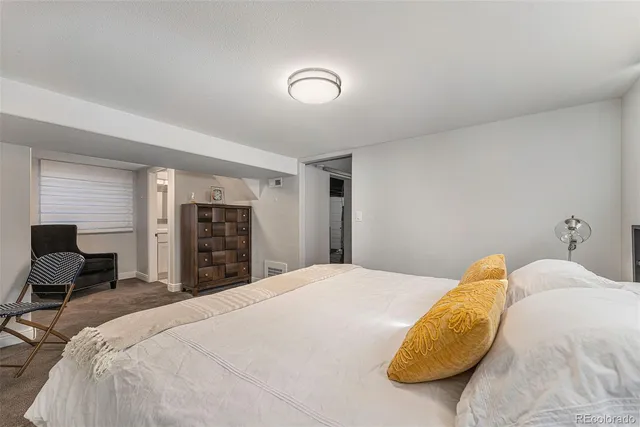 a bedroom with a bed and dresser with mirror