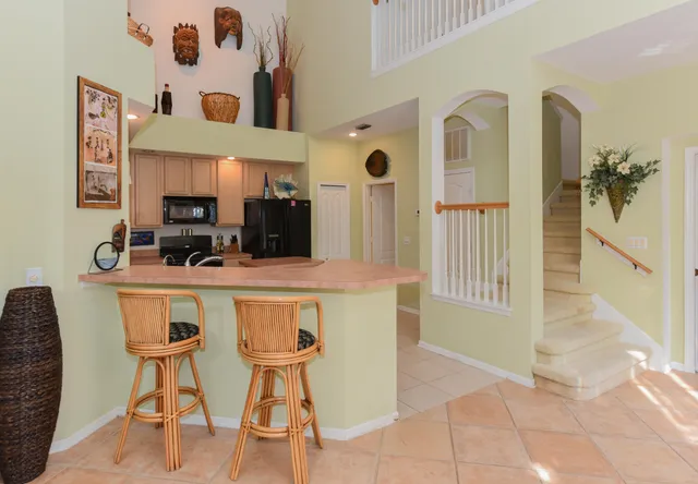 a dining hall with stainless steel appliances kitchen island granite countertop furniture and a kitchen view