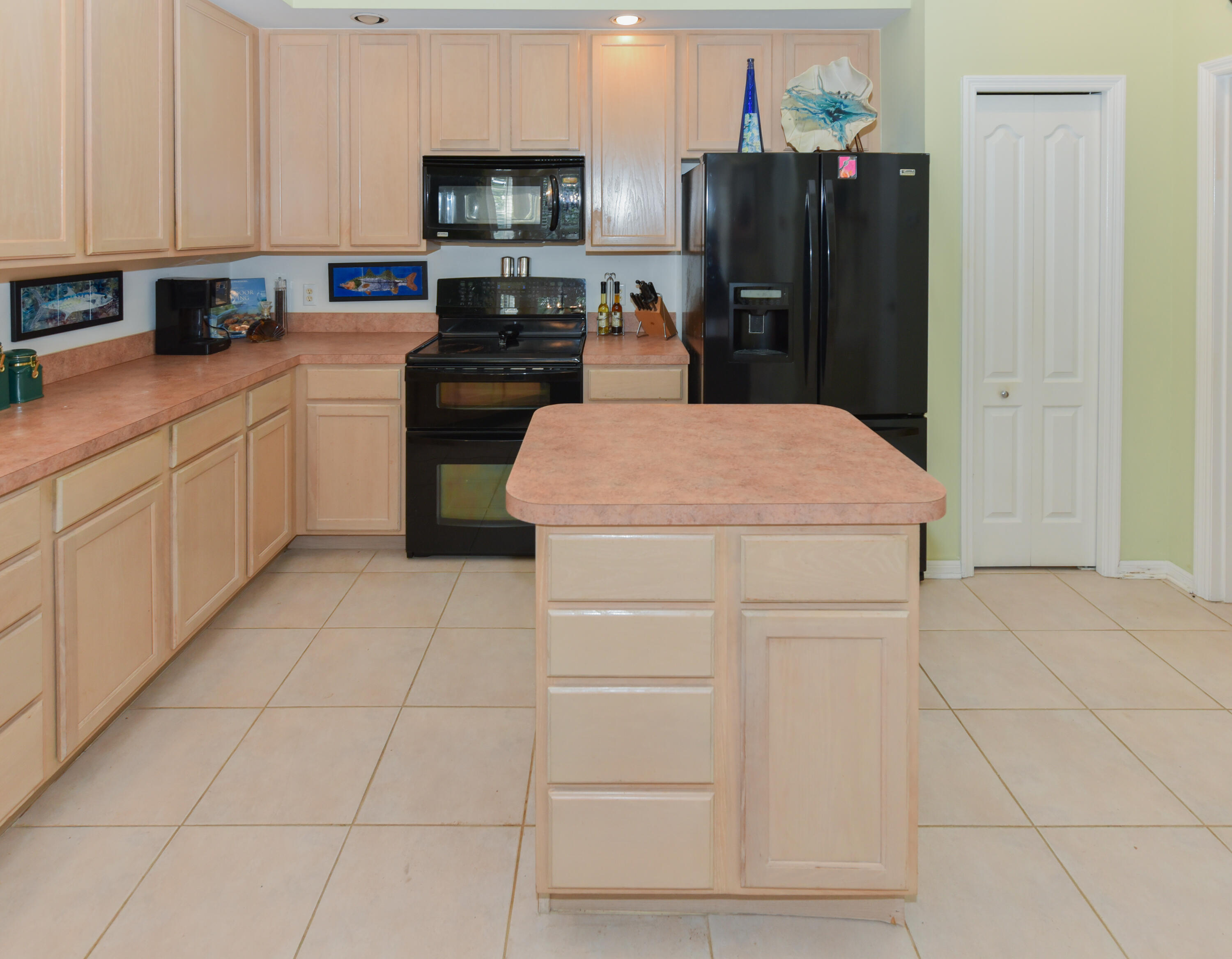 1567 Southwest Harbour Isles Circle, Unit 65 St. Lucie West, FL 34986 - Photo 19 of 35 a kitchen with a refrigerator and cabinets