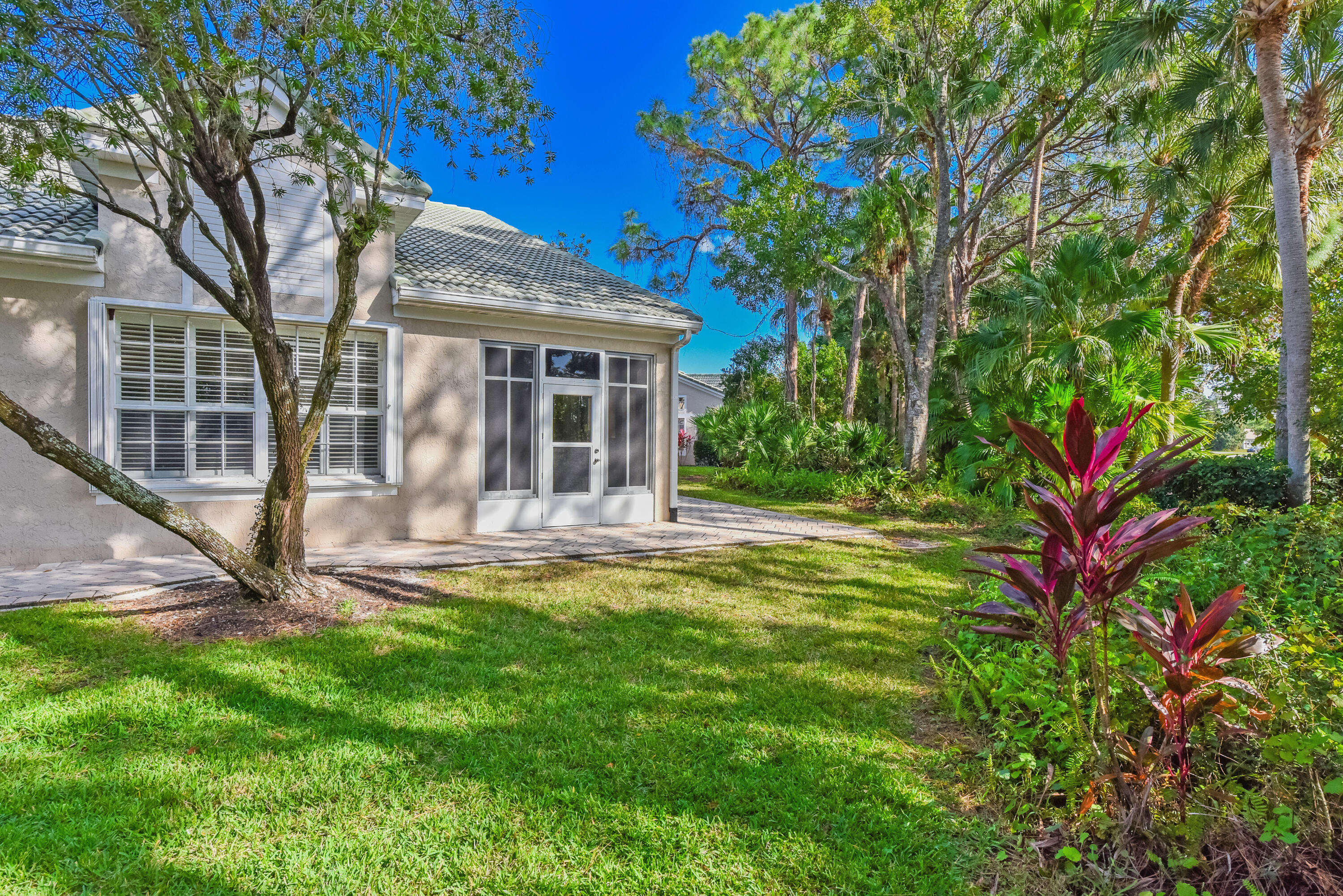 1567 Southwest Harbour Isles Circle, Unit 65 St. Lucie West, FL 34986 - Photo 34 of 35 a front view of a house with a yard and glass windows