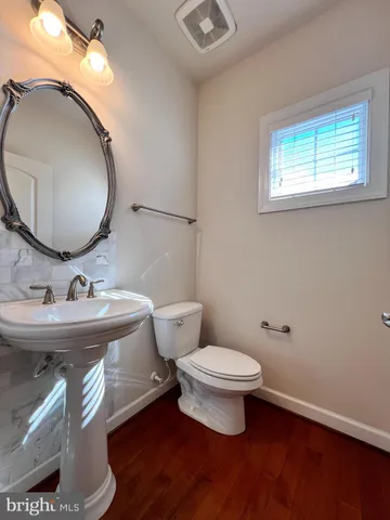 a bathroom with a toilet a sink and a mirror