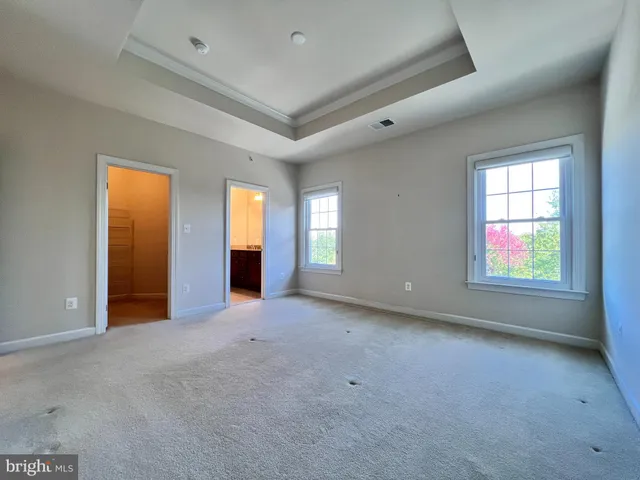 an empty room with windows and closet