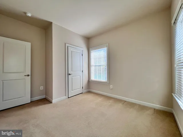 an empty room with windows and closet
