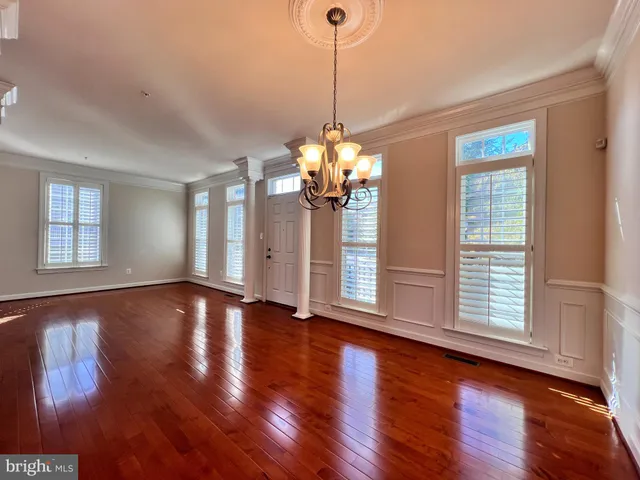 a view of a room with wooden floor and chandelier