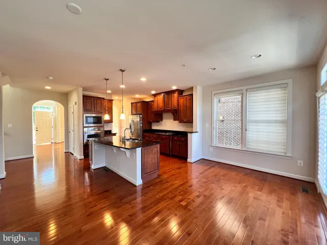 a view of kitchen with kitchen island dining table and wooden floor