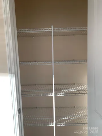 a utility room with a washer dryer and white cabinets
