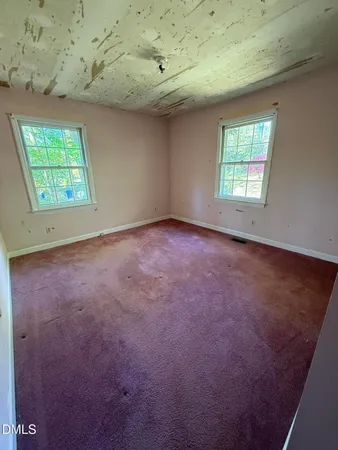 an empty room with a ceiling fan and window