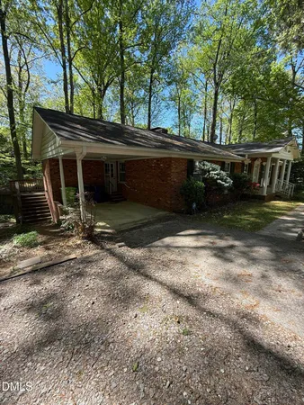 a view of backyard with wooden fence and large trees
