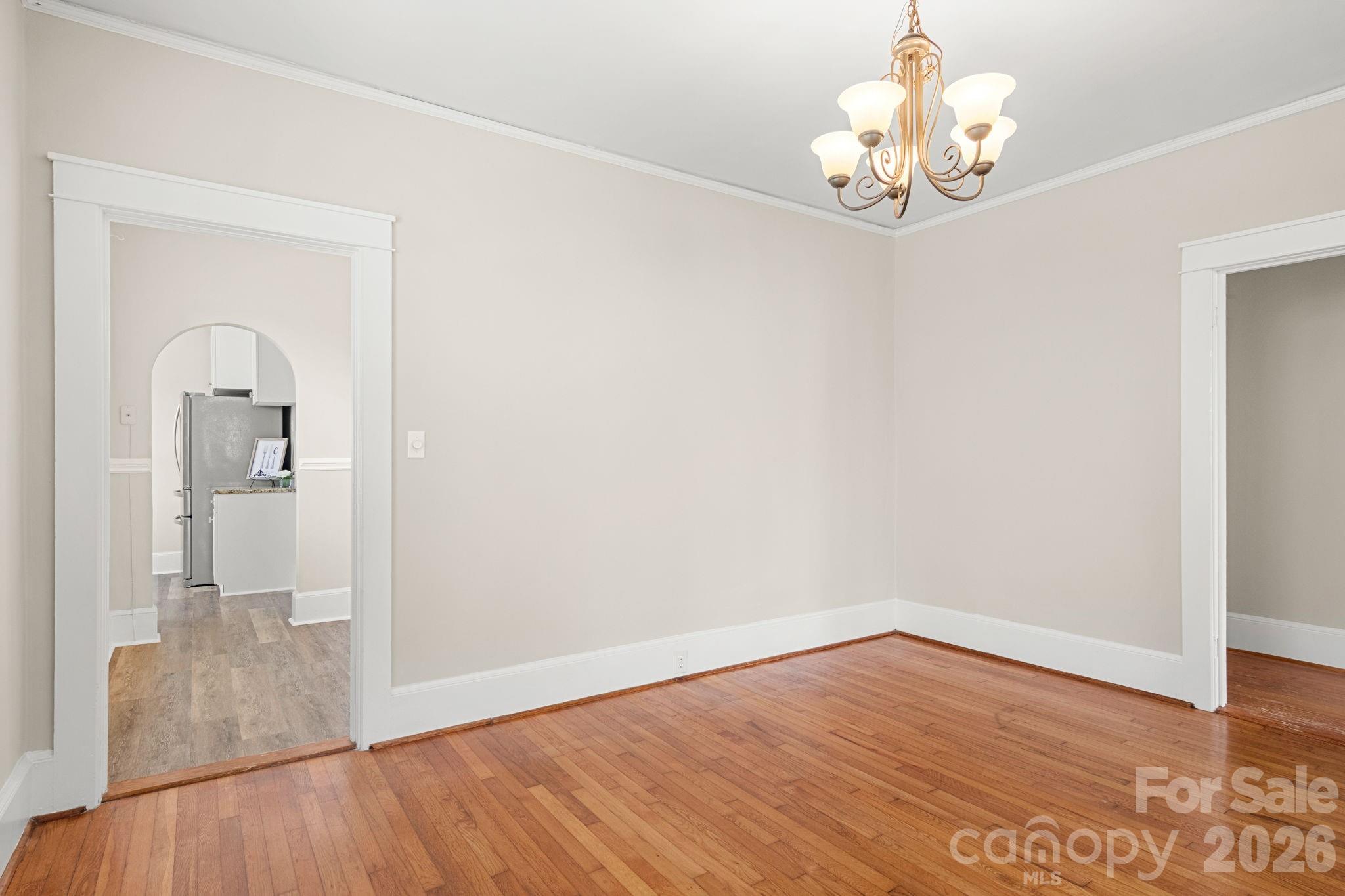 108 Reedy Street Chester, SC 29706 - Photo 9 of 42 an empty room with wooden floor and chandelier