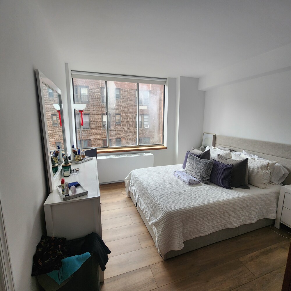 420 East 58th Street, Unit 16C Manhattan, NY 10022 - Photo 4 of 8 a bedroom with a bed and a couch