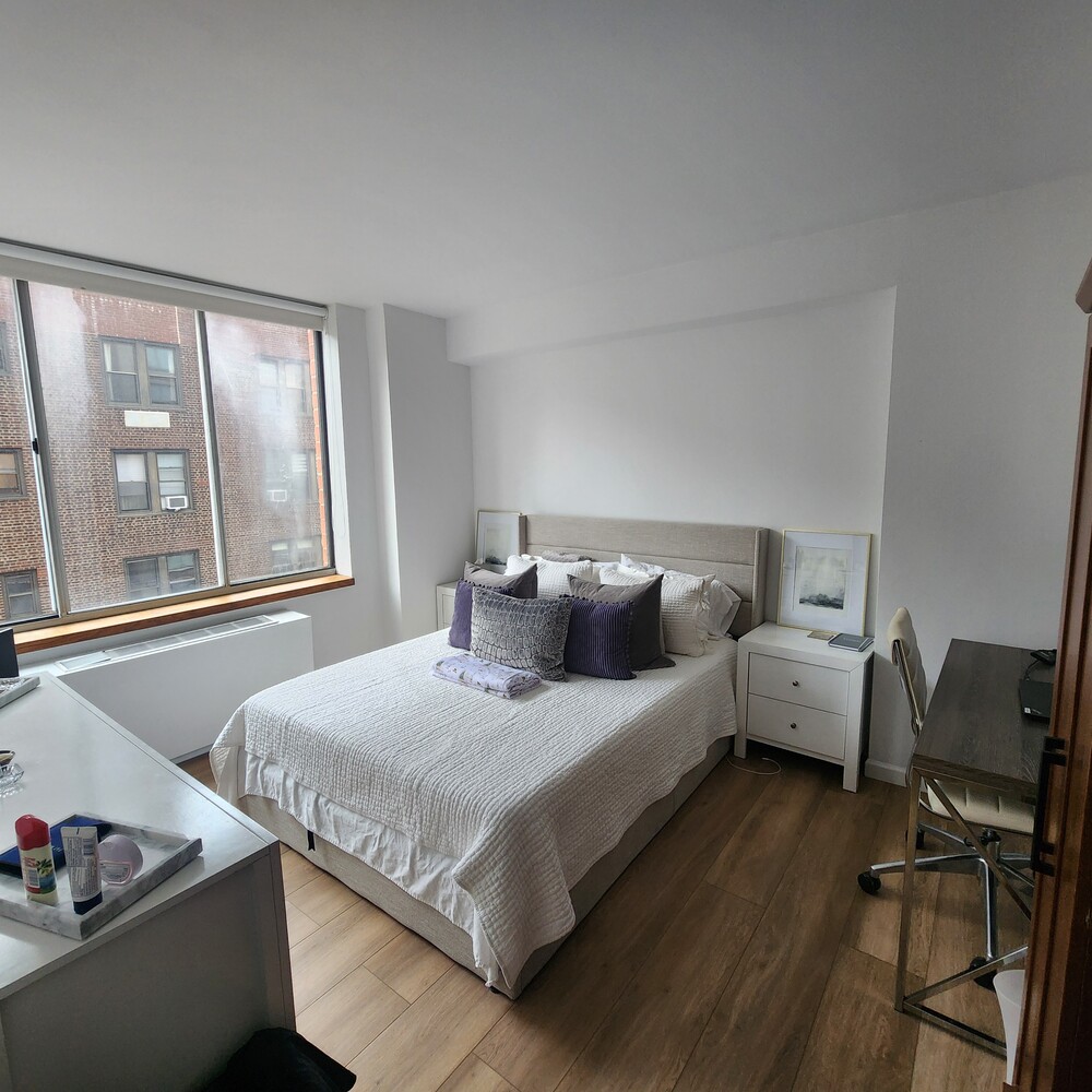 420 East 58th Street, Unit 16C Manhattan, NY 10022 - Photo 5 of 8 a bedroom with a bed and wooden floor