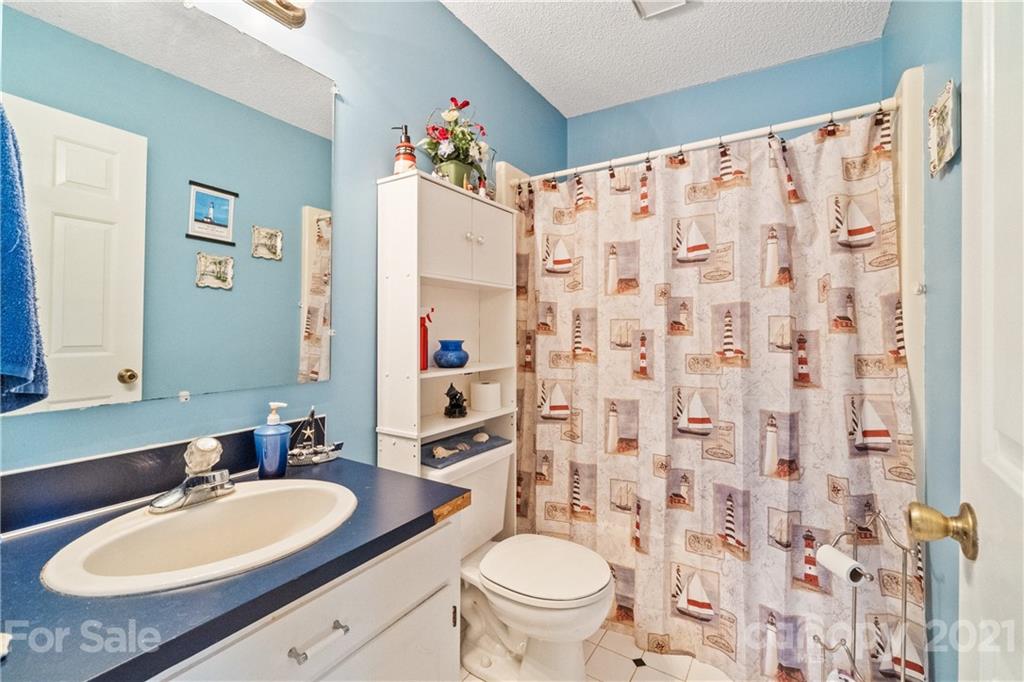 2335 Elbow Road Newton, NC 28658 - Photo 22 of 33 a bathroom with a granite countertop toilet sink and mirror
